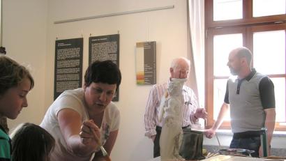 Klein und Groß interessieren sich am Sonntag im Stadtmuseum für die theoretischen und praktischen Ausführungen von Kirchenmalermeisterin Monika Müllner und ihrem Bruder, Vergoldermeister Tobias Müllner, zum Thema "Faszination Gold - Vergolden und restaurieren".  	Bild: tu