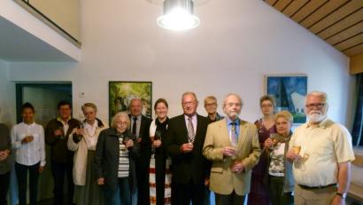 Mit Sekt stoßen Pfarrerin Anne Utz (Sechste von links) sowie die Bürgermeister Peter Lehr (links daneben) und Klaus Lehl (Sechster von rechts) mit Mitgliedern der evangelischen Kirchengemeinde auf die neue Steuerung der Glockenuhr an.  	Bild: rn