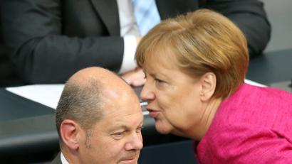 Finanzminister Olaf Scholz (SPD) und Bundeskanzlerin Angela Merkel (CDU) während der Plenarsitzung des Bundestages im Gespräch.  	Bild: Wolfgang Kumm/dpa