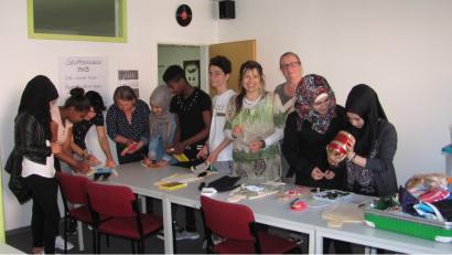 Schüler von Agnes Hehenberger (Vierte von rechts) mit Migrationshintergrund arbeiten mit Textildesignerin Gabriele Siegl (Dritte von rechts) an einem Kunstprojekt. Malerin Stefanie Stangl (Vierte von links) ist ebenfalls mit von der Partie bei diesem ganz besonderen Projekt. Am 2. Juli werden die Werke in Weiherhammer ausgestellt. 	Bild: SEI