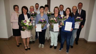 Stellvertretende Pfarrgemeinderatssprecherin Luzia Stingl (links), Pastoralassistent Andreas Hornauer (hinten) und Pfarrer Josef Irlbacher (rechts) verabschieden im Verlauf der Pfarrversammlung die scheidenden Pfarrgemeinderäte nach teils über 20 Jahren Einsatz.  	Bild: ads