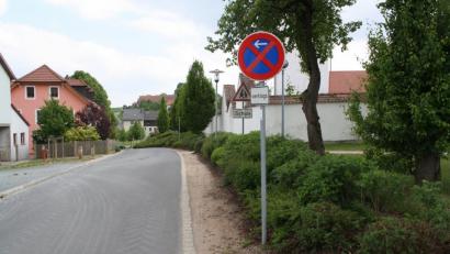 Sieht aus wie ein absolutes Halteverbot, ist aber keins: Nach wie vor gilt auf der Ortsstraße beim Burkhardsreuther Friedhof nur ein eingeschränktes Halteverbot, der zweite rote Schrägbalken wurde von einer unbekannten Person eigenmächtig aufgeklebt.  	Bild: bjp
