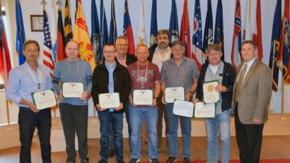 Hohe Auszeichnung für die Hohenfelser Flugberater der US-Army in Hohenfels: Teamleiter Dietmar Meier (von links), Uwe Möstl, Konrad Liebl, Clifford Hiltl, Manfred Wittka, Rudolf Schulze und Deputy-Garrison-Manager Michael Mathews. Johann Merz (zweite Reihe) und Frank Werwie.	Bild: bö