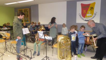 Aktive Musiker der Blaskapelle lassen Kinder und Lehrer der Grundschule Ammerthal an ihren Instrumenten üben.	Bild: mof