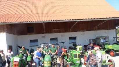 Zweiter Bürgermeister Karl Liegl (links vom Bulldog) und Feuerwehr-Vorsitzender Peter Schwabl (rechts vom Bulldog) begrüßen beim Oldtimertreffen in Lerau die größte Gruppe, den Zapfwellenstammtisch "Alts Glump" aus Mantel.	Bild: sl