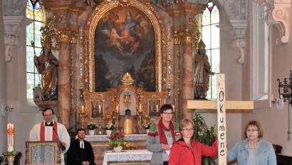 Mit zwei Holzbalken wird in dem ökumenischen Pfingstgottesdienst ein Kreuz gebildet - als Symbol, dass Katholiken und evangelische Gläubige dennoch viele Gemeinsamkeiten haben.  	Bild: rgr
