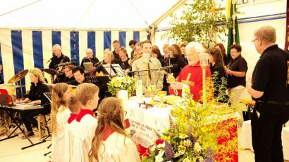 Pfarrer Andreas Schlagenhaufer zelebrierte den Festgottesdienst, im Bild mit den Ministranten, Kommunionhelfern und dem Musikkreis	Bild: Hans Fischer