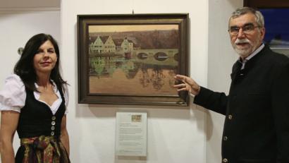 Bild: Herda, Jürgen [JRH] 
Angela Weigert und Martin Meyer vor Schilbachs Kallmünz-Gemälde aus den 1920er Jahren, ein Geschenk der Witwe des früheren SPD-Landtagsabgeordneten Xaver Wolf.