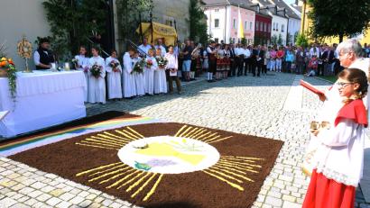 Bild: do
Im Mittelpunkt der feierlichen Fronleichnamsprozession steht die Monstranz mit Hostie als Zeichen der leiblichen Gegenwart Jesu Christi in Brot und Wein. Der farbenprächtige  Motiv-Teppich vor dem vierten Altar auf dem Kirchplatz ist ein Werk des Frauenbundes.