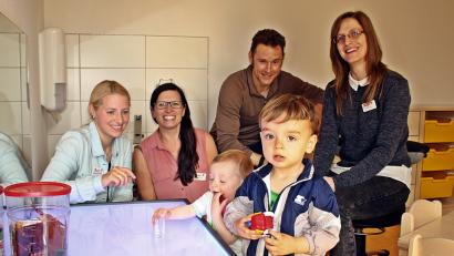 Bild: KZR
In der Krippe steht ein sogenannter Leuchttisch, an dem die Kinder auch mit Spielsteinen Formen und Musterbilder legen können. Leiterin er neuen Einrichtung  ist Sabrina Kraus (Zweite von links).