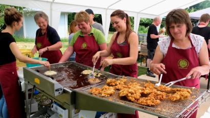 Bild: le
Ihre ganze Routine spielten die Frauen mit Hannelore Geisler ( links ) und ihrem eingespielten Team beim Ausbacken der goldbraunen Hollerkücheln aus.