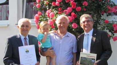 Bild: nbu
Zum 75. Geburtstag von Martin Scheidler, hier  mit Enkelin Emilia (Mitte), gratulieren Bürgermeister Norbert Bücherl (rechts) und 2. Bürgermeister Helmut Klier (links) für den Markt Freihung.