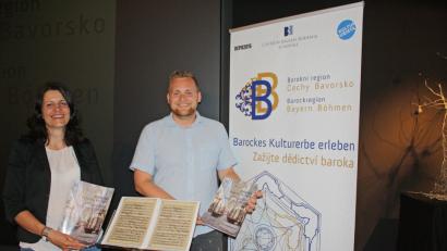 Bild: eib
CeBB-Leiterin Veronika Hofinger und Projektmanager Sebastian Lesňák präsentieren das Magazin der Barockregion Bayern-Böhmen. Im Vordergrund ein Notenblatt des böhmischen Komponisten Johann Antonin Reichenauer, dessen Werke Teil des Konzertprogramms des Projektorchesters sind.