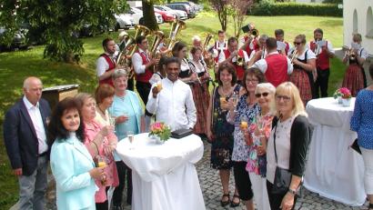 Bild: ld
Das besondere Patrozinium zum 80jährigen Bestehen der Pfarrkirche feiern die Gläubigen auf dem Kirchplatz. Dort stoßen auch Pater Joy (Mitte) und Gemeindereferentin Gabi Sieder (Vierte von rechts)  auf das freudige Ereignis an.
