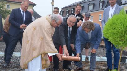 Bild: Kunz
Stadtpfarrer Gerhard Pausch, Bürgermeister Lothar Höher und Architekt Manfred Schwemmer legen die Zeitkapsel ins Fundament des neuen Pfarrheims.