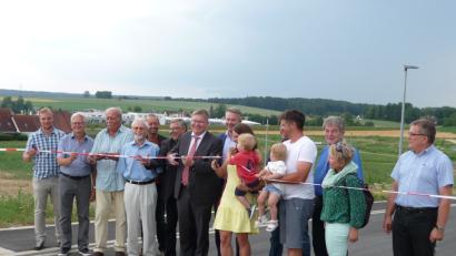 Bild: Sandig, Kristina [SAN]
OB Michael Cerny durchtrennt ein Trassierband, um das Baugebiet Drillingsfeld II einzuweihen.