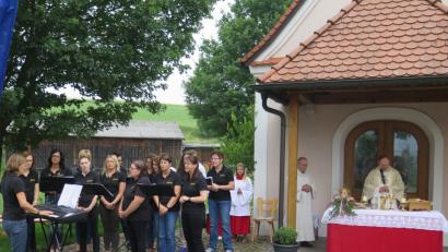 Bild: jzk
Der Chor „Laudate“ (links) gestaltet mit Liedern den Festgottesdienst, den Pfarrer Heribert Stretz (Mitte) vor der Kapelle zelebriert.