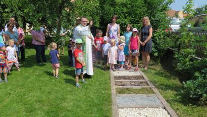 Bild: Zaglmann, Josef [JZK] (zaglmann@t-online.de)
Vor den beiden Gruppenleiterin Renate Pressler und Simone Beck (von rechts), den Kindern und Eltern segnet Stadtpfarrer Konrad Amschl den Barfußpfad.