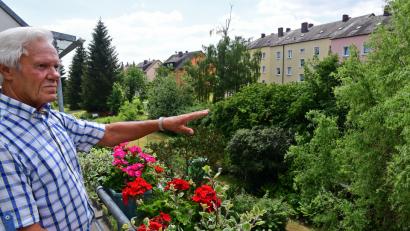 Bild: Petra Hartl
Das Wohnungsunternehmen möchten das Areal zwischen den Wohnblocks an der Hockermühlstraße und der Fürstenhofstraße (oben rechts) neu gestalten. Es sollen unter anderem Stellplätze für Autos entstehen. Bewohner Günter Walter deutet auf den Grünstreifen. Er befürchtet, dass damit eine Ruhezone vernichtet wird.