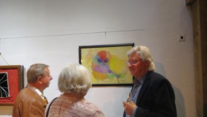 Bild: ubb
Künstler Tom Brankovic (re.), der in beiden Vereinen daheim ist, erklärt zwei Weidener Vereinsfreundinnen die Beweggründe seiner Malerei mit Titel "Kosmische Rose".