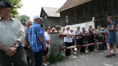 Bild: roh
Am restlichen Grenzzaun   erläutert Susanne Bürger den Friedenfelser Besuchern den Verlauf der einst das Dorf teilende Mauer am Grenzbach „Tambach“
