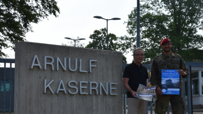 Bild: exb
Bürgermeister Franz Reichold und Oberstleutnant Jörg Witoschek präsentieren
am Eingang der Arnulf-Kaserne die Info-Plakate für den "Tag der
offenen Tür" und den "Mudrun".