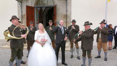 Bild: bsc
Revierjäger Jonas Ständer (rechts neben der Braut) beeindruckte  mit den Jagdhornbläsern Waldsassen nicht nur seine frisch angetraute Ehefrau Isabella. Nach dem "Jägermarsch Nummer 3" unter der Leitung von Bernhard Stier (links) erklang  am Kirchenvorplatz großer Applaus.