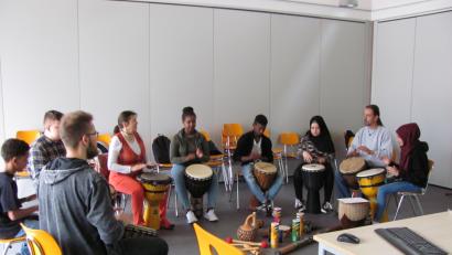 Bild: sei
Gerd Fenzl (Zweiter von rechts) und Daniel Bayer (links)  trommeln am Montag in Weiherhammer mit Schülern mit Migrationshintergrund.