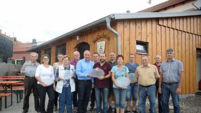 Bild: brü
Übergabe der Hausnamenschilder in Köfering. Überreicht werden diese an die Besitzer der Anwesen und Häuser durch Bürgermeister Roland Strehl und HKV-Vorsitzenden Josef Vogl (Bildmitte mit Schild). Auf den Schildern ist der jeweilige Hausname mit einer kurzen Beschreibung dieses verewigt.