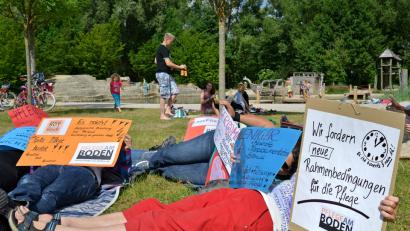 Bild: Hartl
Beim Flashmob „Pflege am Boden“ 2014 legten sich 35 Demonstranten symbolisch auf die Wiese im ehemaligen Landesgartenschaugelände.  Der selbst gebaute Leuchtturm sollte auf den fehlenden Pflegestützpunkt in der Oberpfalz hinweisen.