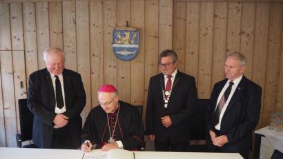 Bild: gz
Bischof Rudolf Voderholzer trägt sich mit Pfarrer Erwin Bauer (links) und Pfarrer Josef Most (rechts) im Beisein von Bürgermeister Reiner Gäbl ins Goldene Buch ein.