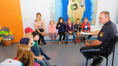 Bild: do
Verkehrserziehung ist ein wichtiger Bestandteil der Schulwegsicherheit. Vor der Praxis auf öffentlichen Straßen und  Gehwegen kommt in der Kindertagesstätte Speinshart für die Vorschulkinder und Erzieherin Annalena Herr eine „Trockenübung“ mit Verkehrserzieher Christian Simon (rechts) von der Polizeiinspektion Eschenbach.