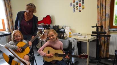 Bild: gi
An den Gitarren zu zupfen geht schon, freuen sich Charlotta und Leonie. Lehrerin Sieglinde Ziegler zeigt, wie man das Instrument richtig hält.
