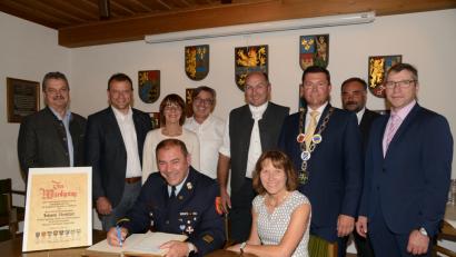 Bild: bey
Die Bürgermeister Andreas Wutzlhofer, Anton Kappl, Margit Kirzinger, Reiner Gäbl, Max Völkl, Rainer Rewitzer, Josef Beimler und Hermann Ach (stehend, von links) danken Ehrenkreisbrandinspektor Johann Rewitzer für die herausragende Zusammenarbeit. Rewitzer trägt sich beim Festakt als erster ins Goldene Buch der Stadt Pleystein ein. Ehefrau Resi war in den 31 Jahren der Tätigkeit Rewitzers der große Rückhalt.
