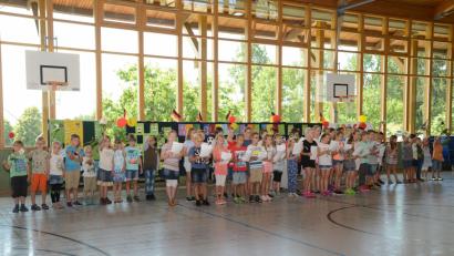 Bild: bey
Die  3. und 4. Klasse singt ein "leichtes Sommerlied. Die 1. und 2. Klasse bilden den bunten Rahmen.