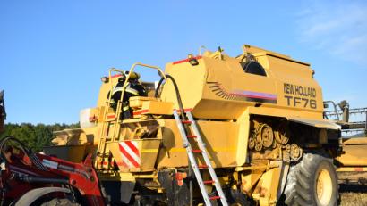 Bild: Jürgen Masching
Während die Atemschutzträger den Mähdrescher nach Glutnestern absuchen platziert ein Landwirt seine Frontladerschaufel unter dem Kraftstofftank, um den auslaufenden Diesel aufzufangen.