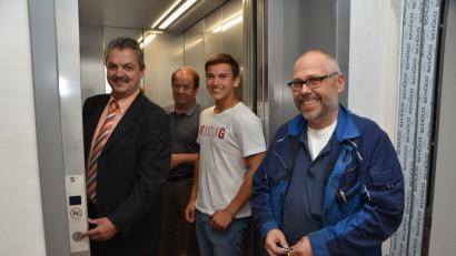 Bild: dob
Es ist geschafft, der Aufzug ist bereit: Der TÜV-Prüfer (rechts) legt letzte Hand an, dann kann Bürgermeister Andreas Wutzlhofer erstmals den Startknopf drücken. Mit dabei sind Architekt Josef Schönberger und Auszubildender Maximilian Rewitzer (von links).