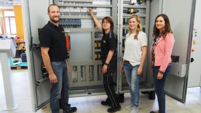 Bild: SBÜ
Stolz zeigt Madeleine Busch (Zweite von links) den von ihr selbstständig ausgestatteten und geprüften Schaltschrank. Er ist für eine Keramikproduktion in Portugal vorgesehen. Mit dabei ihr Fertigungsleiter Tobias Busch von der Lippert GmbH & Co KG sowie Christine Ritter vom ÜBZO in Weiden und Christina Schönberger vom Jobcenter Weiden-Neustadt (Dritte und Vierte von links)