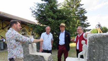 Bild: ubb
Die Steinskulptur von Bildhauer Tilo Ettl (Mitte) aus Plana bleibt in Wiesau. Bürgermeister Toni Dutz (rechts) hat sie gekauft. Gemeinsam mit Wigg Bäuml, dem Vorsitzenden des Bundesverbandes für Bildende Kunst Oberpfalz (links) und dem Künstlerkollegen Axel T Schmidt (vorne) wird besprochen, ob das Kunstwerk am Bahnhof bleiben oder einen anderen Standort bekommen soll.