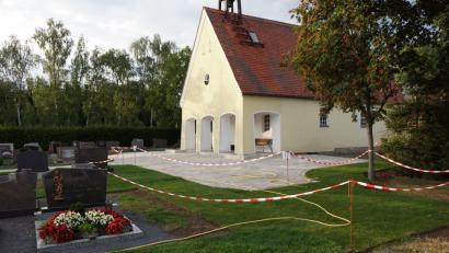 Bild: bkr
Die ersten Arbeiten an der Neugestaltung des Friedhofs sind abgeschlossen. Im kommenden Jahr geht es weiter. Entlang der Hauptgehwege grünt Rollrasen und zum Friedhofsgebäude führt nur noch eine Treppe. Der Vorplatz ist gepflastert.