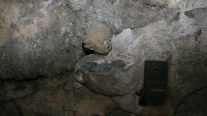 Bild: wro
Der steinerne Engel im Inneren der Grotte hält einen Weihwasserkessel in der Hand. Mit beiden Augen „bewacht“ er fest den Opferstock.