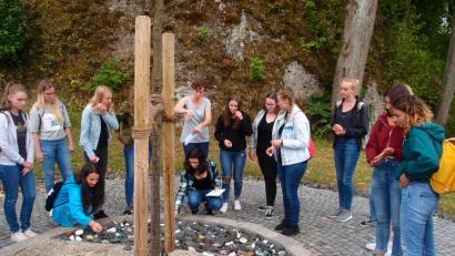 Bild: exb
Die Schüler legten am „DenkMal“ – ein Baum mit zwei großen schweren Platten – symbolisch Steine ab, damit nicht vergessen wird, was nicht vergessen werden darf.