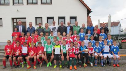 Bild: khg
Stolz präsentieren sich die vier besten Jungen-Teams aus (von links) Auerbach, Vilseck, Freudenberg und Illschwang nach der Grundschul-Landkreismeisterschaft mit den Ehrengästen. Die Meister bekommen von der Sparkasse Amberg-Sulzbach T-Shirts, die folgenden neun Teams Bälle von Bürgermeister Hans-Martin Schertl und Günter Simmerl (Conrad-Sportförderung). Besonders geehrt werden die besten Torschützen: Lukas Merkl (10 Tore/Auerbach), Jakob Piehler (8/Freudenberg), Noah Keller (7/Illschwang) sowie (je 5 Tore) Zaid Al Osman (Pestalozzi) und Nils Lorenz (Auerbach), Simon Schmidt (4/Illschwang) und (je 3) Jonas Germershausen, Benedikt Liebenow und Noah Ziegler (alle Vilseck I).