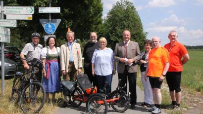 Bild: den
Die Teilnehmer der Fahrradsternfahrt zu den „Simultankirchen des Jahres“ sind die ersten, die sich über den druckfrischen Kirchenführer freuen. Mit dabei (von links): Pfarrer und Vorsitzender des Fördervereins Hans-Peter Pauckstadt-Künkler, Elvira Freifrau von Lindenfels und Bertold Freiherr von Lindenfels, Historiker Harald Stark, Pfarrerin Nadine Schneider, Bezirkstagspräsident und Schirmherr Franz Löffler, Kreisrätin Brigitte Scharf, Regionalbischof Hans-Martin Weiss und Bürgermeister Uli Roth.
