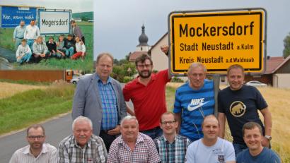 Bild: ow
Den Besuch des Bürgermeisters der Partnergemeinde Mogersdorf aus Österreich nutze eine Gruppe Feuerwehrler um wie vor 24 Jahren in Österreich vor dem Ortsschild ein entsprechendes Bild zu machen. In der linken oberen Ecke ist das alte Bild zu sehen. Vordere Reihe: Armin Hofmann, Hermann Gmelch, Wolfgang Brandl, Klaus Deubzer, Michael Dötsch, Stefan Walter. Hintere Reihe: Josef Korpitsch, Wolfgang Haberberger (im Bild 1994 Karl Pühl), Hermann Leiter und Markus Walter.