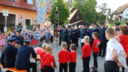 Bild: Portner
Die Feuerwehr Kühried (rechts) gab erst nach vier bestandenen Aufgaben die Zusage zur Übernahme der Ehrenpatenschaft. Die Kührieder Festdamen feuerten vorm Gerätehaus mit Gstanzln an.