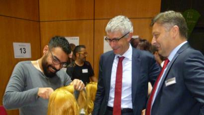 Bild: (usc)
Salim Abo Harash, der 2015 als junger Flüchtling in Amberg landete, erläuterte als Friseur-Azubi IHK-Vizepräsident Dr. Rolf Pfeiffer (Mitte) und IHK-Geschäftsführer Bernhard Reif einige bereits erlernte Fertigkeiten.