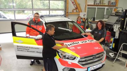 Bild: mor
Stellvertretender Bereitschaftsleiter Patrick Hößl und HvO-Leiterin Jasmin Träger (in Einsatzkleidung) freuen sich über das neue Einsatzauto. Tanja und Bernd Hutzler bekleben in ihrer Firma das Auto.