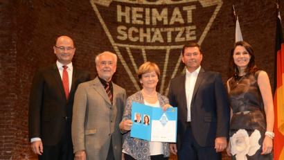 Bild: bey
Finanz- und Heimatminister Albert Füracker (links) übergibt gemeinsam mit Wissenschafts- und Kunstministerin Professor Dr. Marion Kiechle (rechts) den Preis an Werner Reger und Grete Reger vom Stadtmuseum Pleystein, die von Bürgermeister Rainer Rewitzer begleitet wurden.