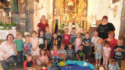Bild: hl
Die Kindergartenkinder vor dem Volksaltar und die symbolisch dargestellte Schöpfungsgeschichte mit Pfarrer Stretz, dem Kindergartenpersonal sowie Leiterin Kerstin Dilling (zweite Reihe, Zweite von rechts).